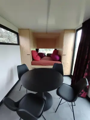a room with a table and chairs and a bed at Kromven Puur Genieten in Merksplas