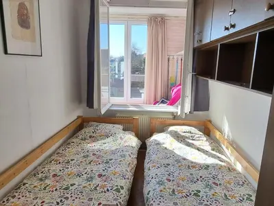 a room with two beds in front of a window at Appartement Ruggeveld in Antwerp