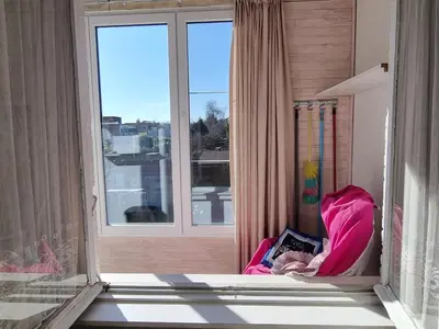 a child sitting in a chair in front of a window at Appartement Ruggeveld in Antwerp