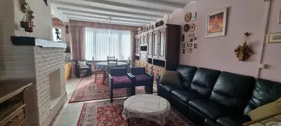a living room with a leather couch and a table at Appartement Ruggeveld in Antwerp