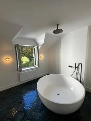 a white bath tub in a room with a window at Superb house in absolute calm in Linkebeek