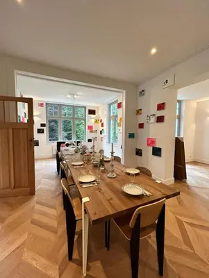 a dining room with a long wooden table and chairs at Superb house in absolute calm in Linkebeek