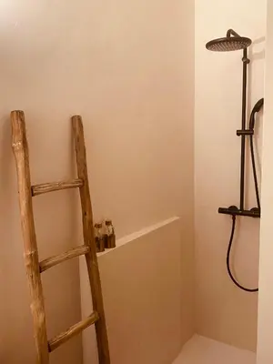 a wooden ladder in a bathroom with a shelf at Bohémien garden room in Ghent