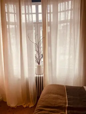 a bedroom with white curtains and a bed and a window at Bohémien garden room in Ghent