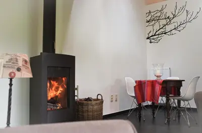 a living room with a fireplace and a table at Geestmolenhof 2 in Holsbeek