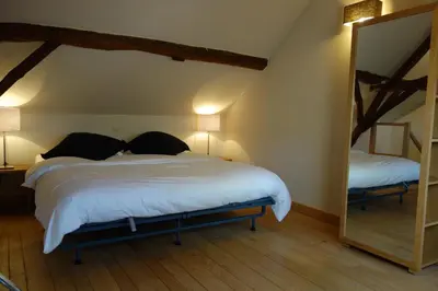a bedroom with a large bed and a mirror at Geestmolenhof 2 in Holsbeek