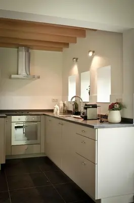 a kitchen with white cabinets and a sink at Geestmolenhof 2 in Holsbeek