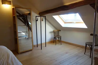 a bedroom with a skylight and a bed and a mirror at Geestmolenhof 2 in Holsbeek