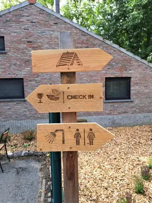 a wooden sign that says check in and i check in at Pop-Up camping close to festival - Ganzendrieshoeve in Rumst