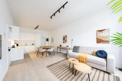 a white living room with a couch and a table at Comfortable Urban Retreat for 6 in Central Antwerp in Antwerp