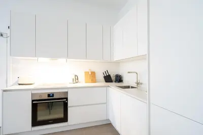 a white kitchen with white cabinets and a sink at Comfortable Urban Retreat for 6 in Central Antwerp in Antwerp