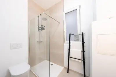 a bathroom with a glass shower with a toilet at Comfortable Urban Retreat for 6 in Central Antwerp in Antwerp
