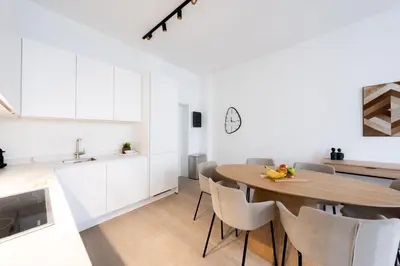 a kitchen and dining room with a wooden table and chairs at Comfortable Urban Retreat for 6 in Central Antwerp in Antwerp