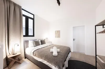 a white bedroom with a bed with a cross on it at Comfortable Urban Retreat for 6 in Central Antwerp in Antwerp