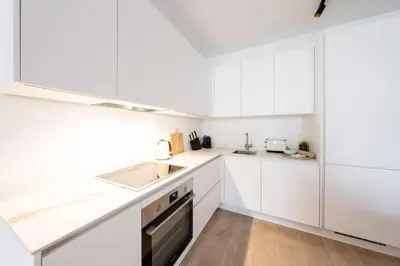 a white kitchen with white cabinets and a sink at Modern 6-Guest Apartment in Central Antwerp in Antwerp