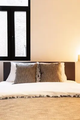 a bedroom with a bed with pillows and a window at Modern 6-Guest Apartment in Central Antwerp in Antwerp
