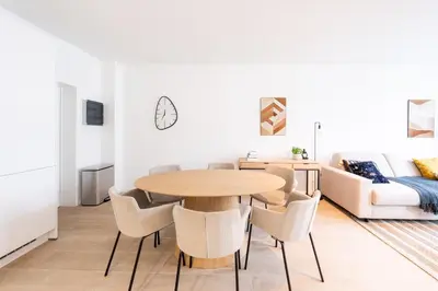 a kitchen and living room with a wooden table and chairs at Modern 6-Guest Apartment in Central Antwerp in Antwerp