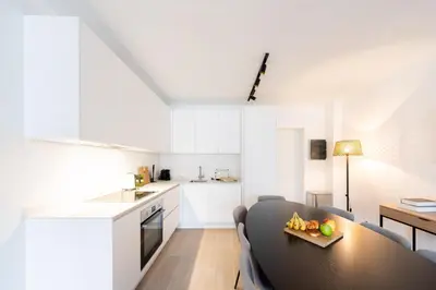 a living room with a table and a kitchen at Stylish Duplex for 8 in Central Antwerp in Antwerp