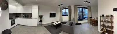 a living room with a couch and a kitchen at Splendide appartement neuf à Zaventem airport in Zaventem