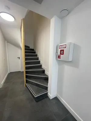 a hallway with a staircase with a dryer on the wall at Splendide appartement neuf à Zaventem airport in Zaventem