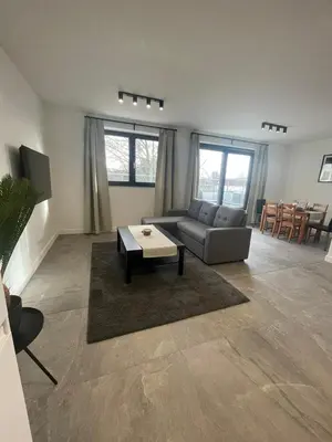 a living room with a couch and a table at Splendide appartement neuf à Zaventem airport in Zaventem