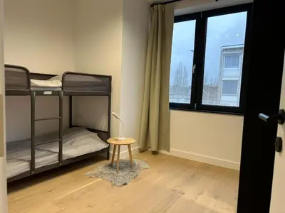 a room with two bunk beds and a table at Splendide appartement neuf à Zaventem airport in Zaventem