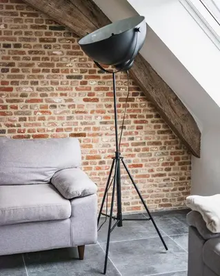 a floor lamp in a living room next to a couch at Sheela Farm in Rumst