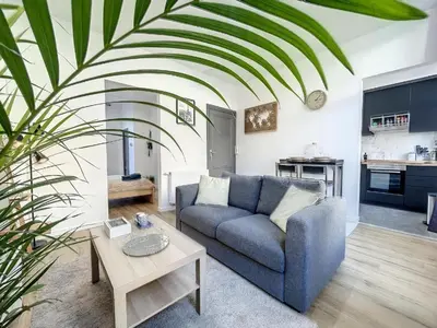 a living room with a blue couch and a table at Cosy Apartment Palais royal in Brussels
