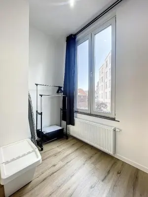 a white room with a large window and a toilet at Cosy Apartment Palais royal in Brussels