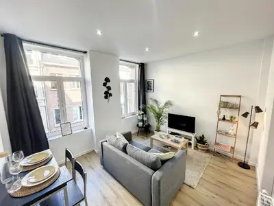 a living room with a couch and a table at Cosy Apartment Palais royal in Brussels