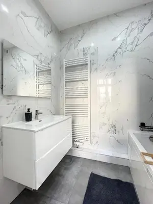 a white bathroom with a tub and a sink at Cosy Apartment Palais royal in Brussels