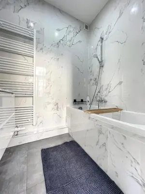 a white bathroom with a tub and a sink at Cosy Apartment Palais royal in Brussels