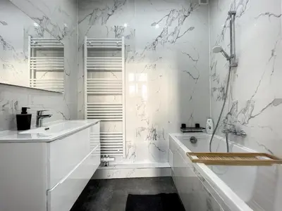 a white bathroom with a tub and a sink at Cosy Apartment Palais royal in Brussels