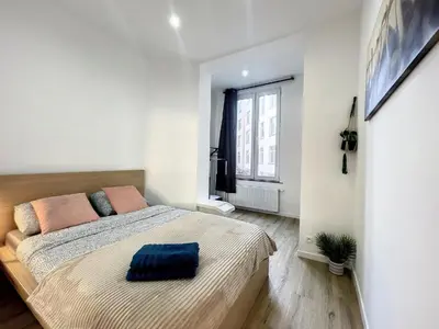 a bedroom with a large bed and a window at Cosy Apartment Palais royal in Brussels