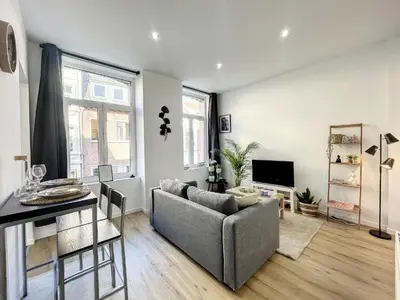 a living room with a couch and a table at Cosy Apartment Palais royal in Brussels