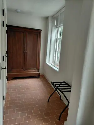 a room with a wooden cabinet and a tiled floor at Begijnhofpoort B&B in Turnhout