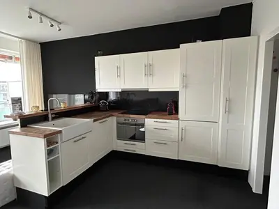 a white kitchen with white cabinets and a sink at Charmant appartement in Antwerpen Zuid met zicht op de stroom in Antwerp