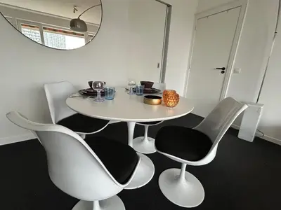 a white table and chairs in a room with a mirror at Charmant appartement in Antwerpen Zuid met zicht op de stroom in Antwerp