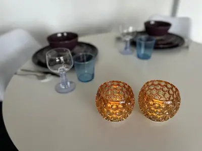 three gold balls on a table with plates and glasses at Charmant appartement in Antwerpen Zuid met zicht op de stroom in Antwerp