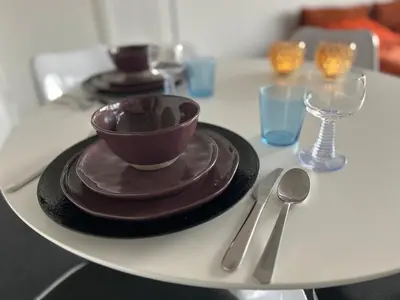 a table with two plates and a cup and a bowl at Charmant appartement in Antwerpen Zuid met zicht op de stroom in Antwerp