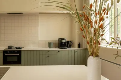 a kitchen with a vase with flowers in it at Begijnhofpoort Vakantiehuis in Turnhout