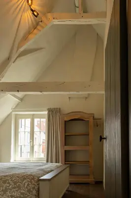 a bedroom with a loft bed with a window at Begijnhofpoort Vakantiehuis in Turnhout
