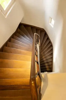 a spiral staircase with a guitar in a room at Begijnhofpoort Vakantiehuis in Turnhout