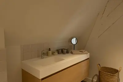 a bathroom with a white sink and a mirror at Begijnhofpoort Vakantiehuis in Turnhout