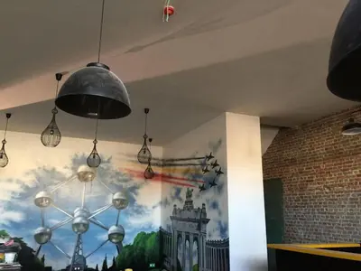a chandelier hanging from a wall with a painting at Midi 81 HOSTEL in Brussels