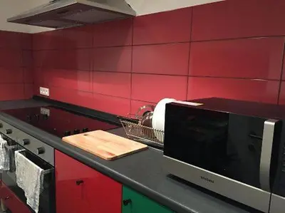 a kitchen counter with a microwave on a red wall at Midi 81 HOSTEL in Brussels