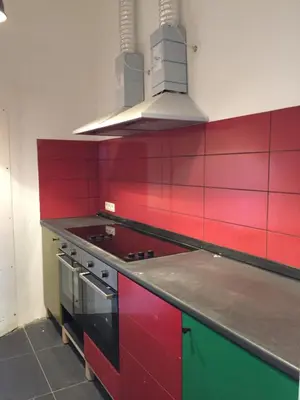 a kitchen with red and green cabinets and a stove at Midi 81 HOSTEL in Brussels