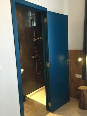 a bathroom with a shower with a blue door at Midi 81 HOSTEL in Brussels