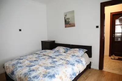 a bedroom with a bed with a blue and white comforter at Cozy family home near LottoArena Antwerpen in Antwerp