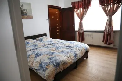 a bedroom with a bed and a dresser and a window at Cozy family home near LottoArena Antwerpen in Antwerp
